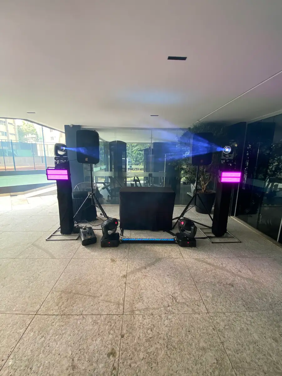 Área coberta de condomínio à tarde, com caixas de som, moving heads, strobos, barra de LED e cabine de DJ montados