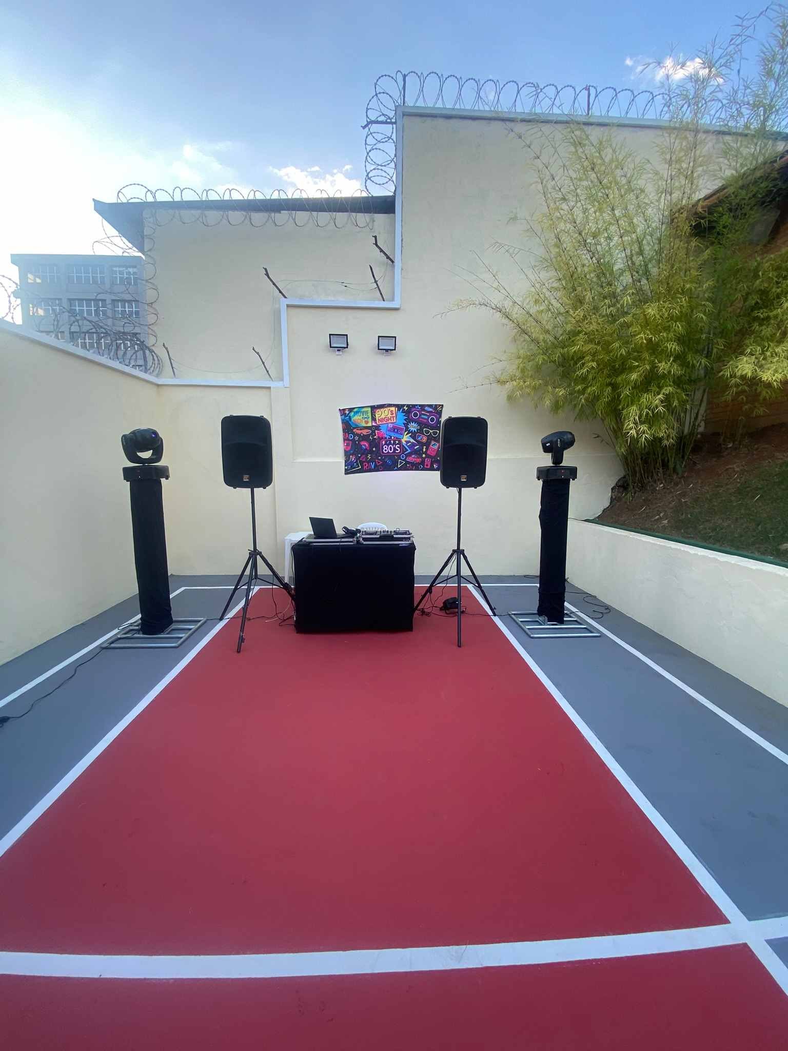 Caixas de som, colunas com moving heads e cabine de DJ montadas na quadra de um condomínio